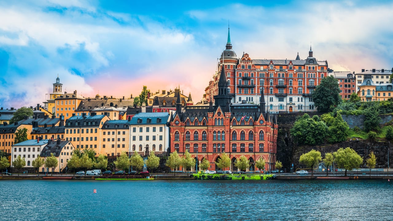Bostadshus i tegel och puts i en sluttning ovanför en kaj vid vatten.