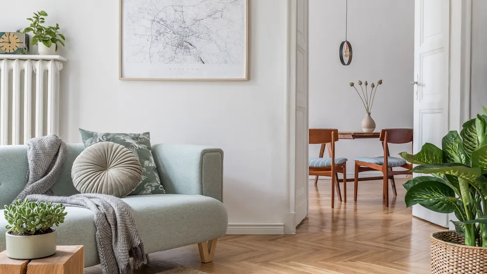 Ljust vardagsrum med soffa och matplats i bakgrunden